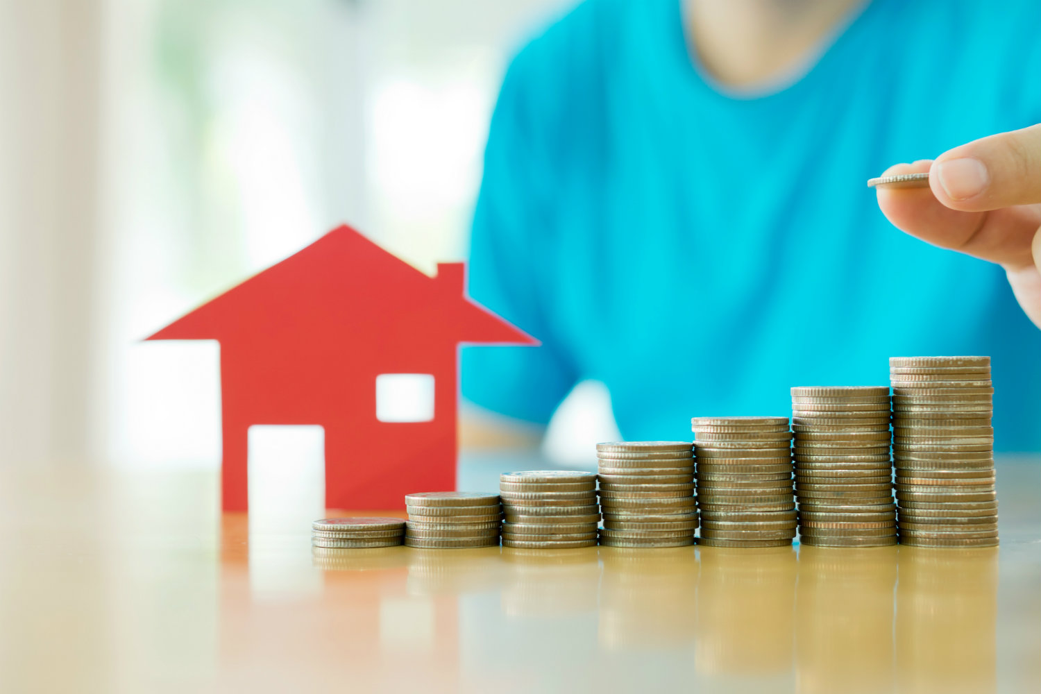 coins stacked in front of house